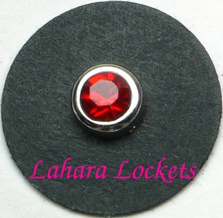 This floating charm is a red, July birthstone surrounded my silver colored metal.
